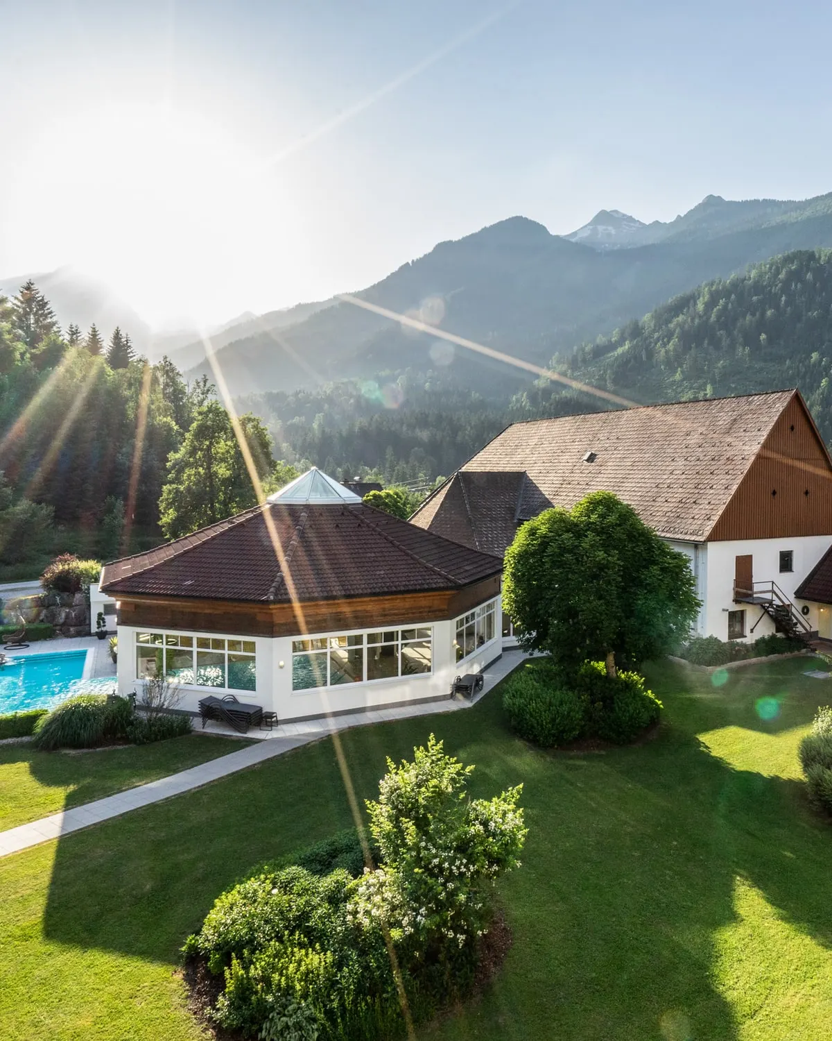 Ranní slunce nad zahradou, bazénovým pavilonem a Poppengutem