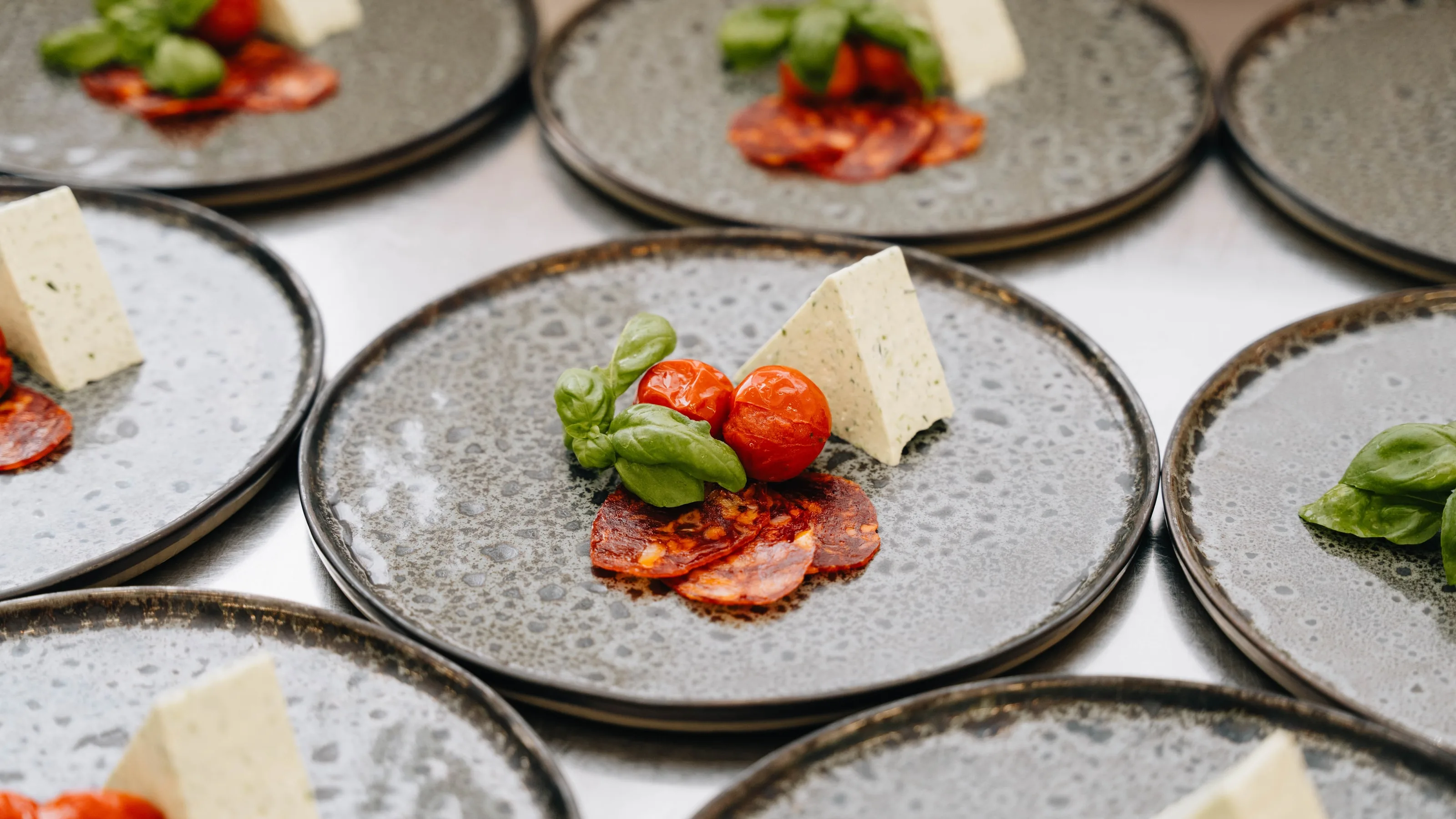 Angerichtete Vorspeisenteller mit Tomate, Basilikum und Käse
