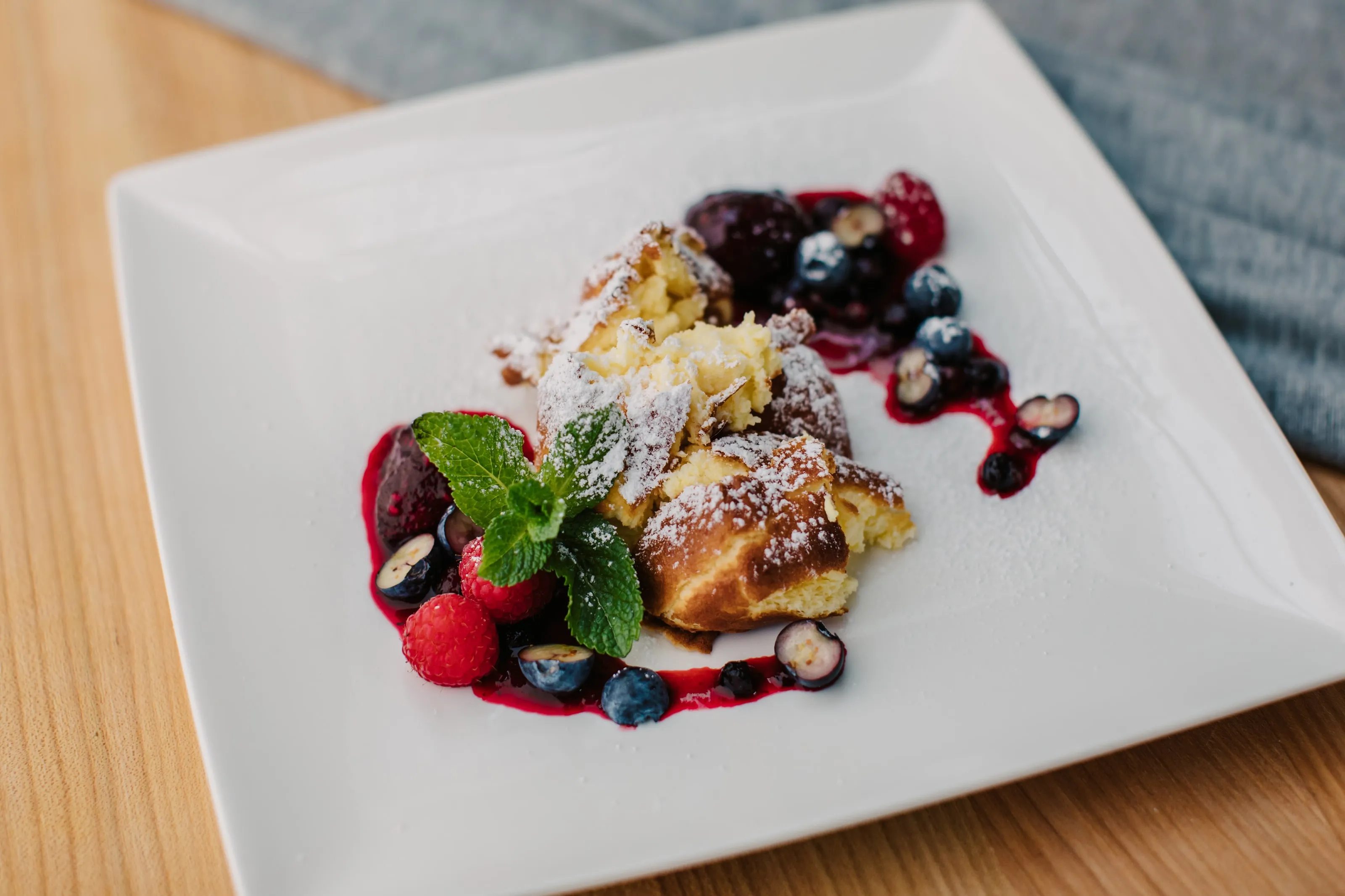 Rahmschmarrn mit Staubzucker, Beerenröster, frischen Beeren und Minze