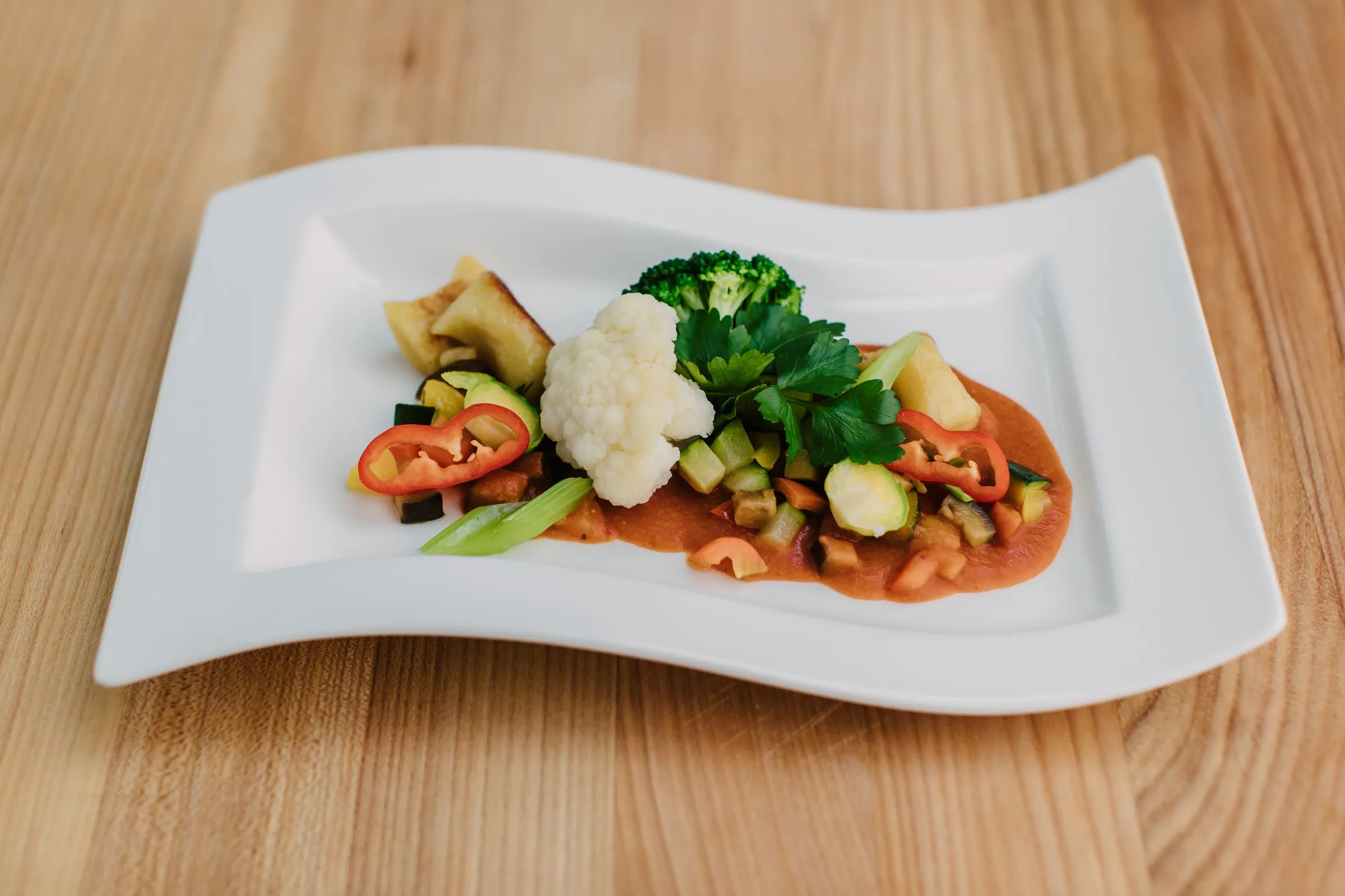 Vegetarischer Teller mit Blumenkohl, Brokkoli, Gemüse und Paprikasauce