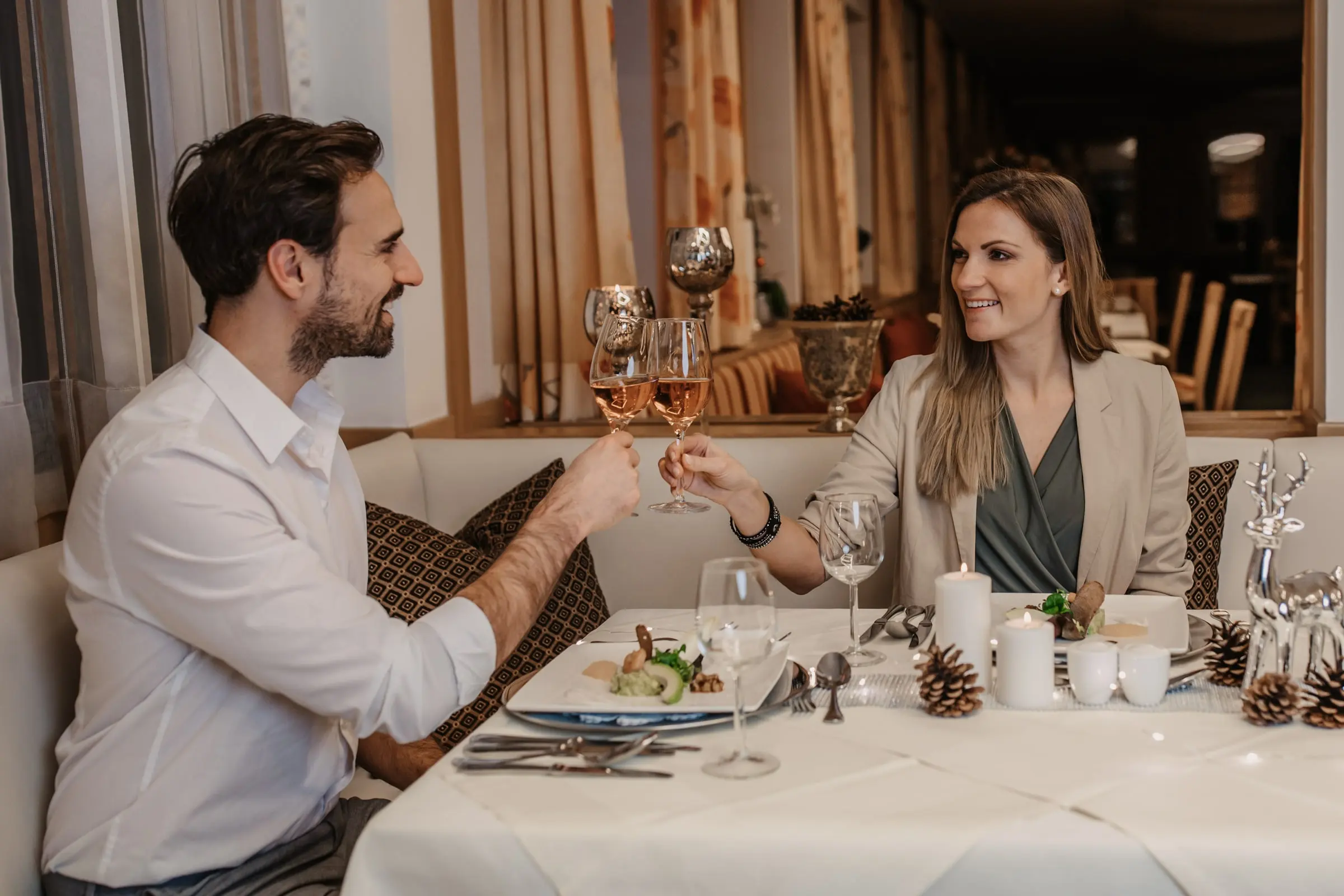 Ein Paar stößt im Winter am gedeckten Tisch an