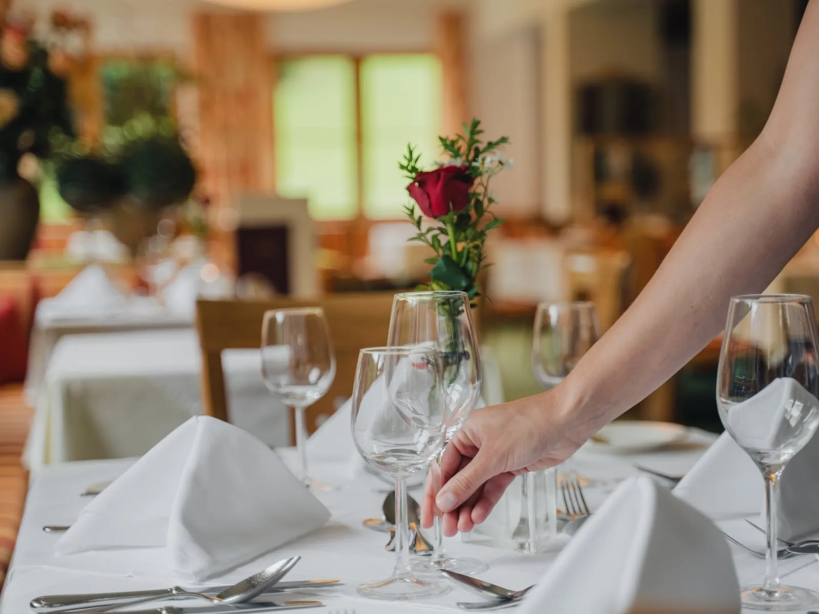 Ein Tisch im Restaurant wird mit einer Rose gedeckt