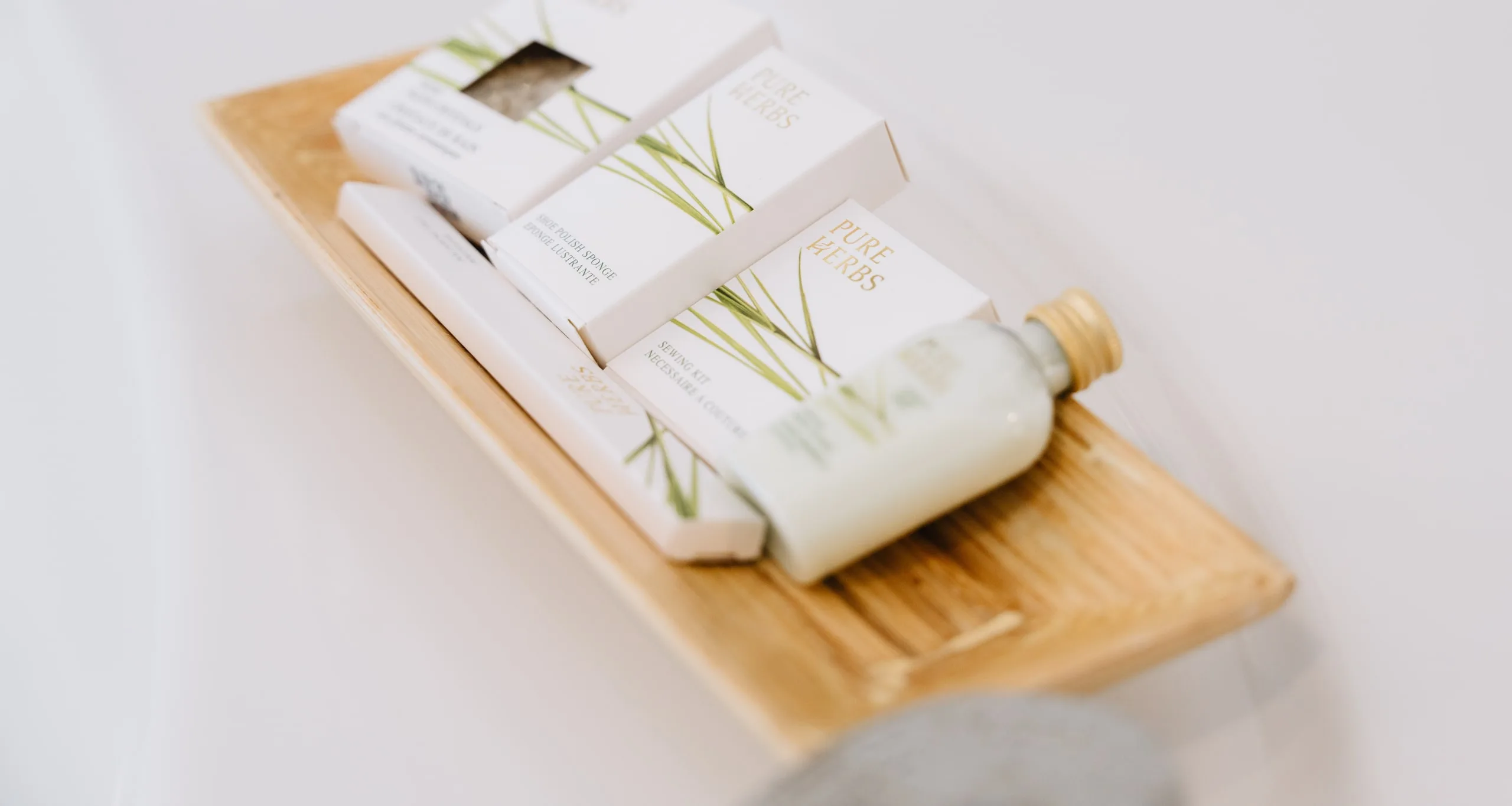 Péče Pure Herbs na dřevěném tácu na okraji vany