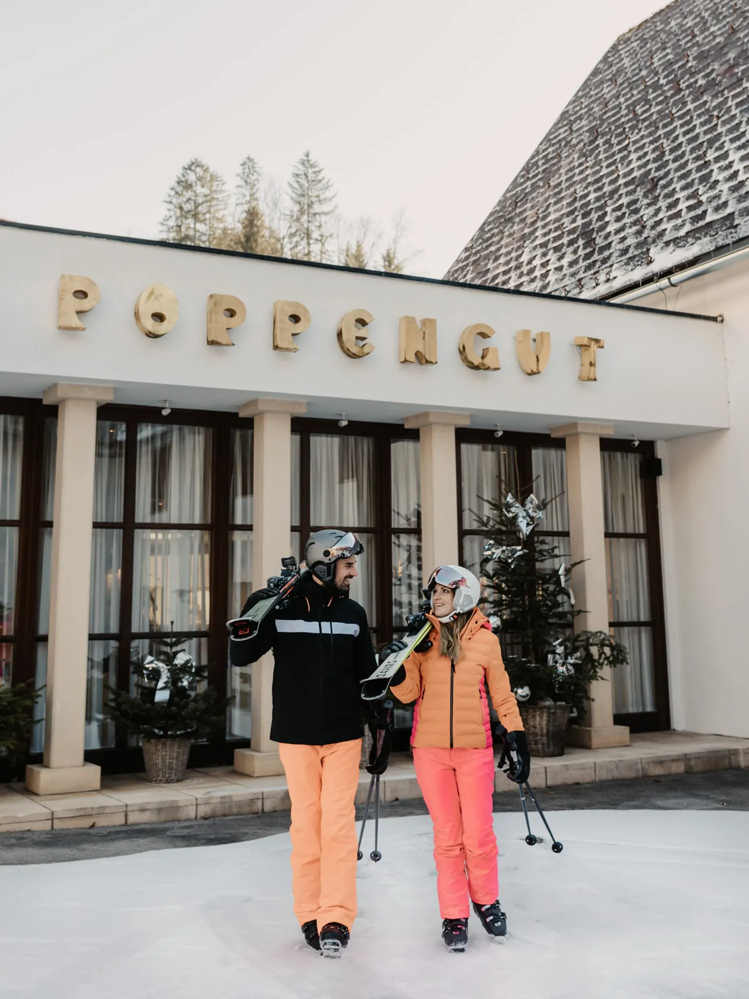© Selina Flasch Photography Pár s lyžemi před vchodem do hotelu Poppengut