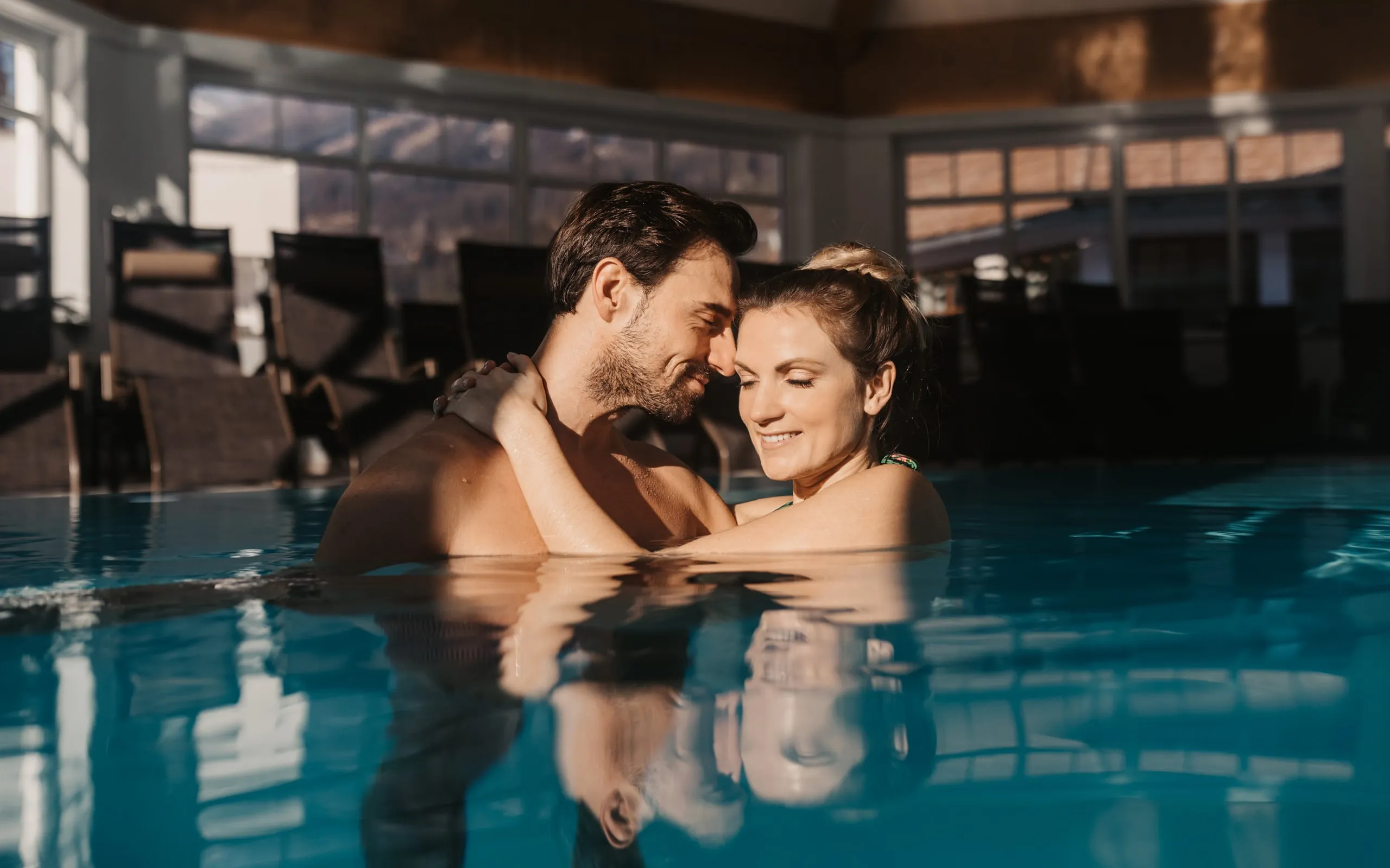 Ein Paar im Innenpool des Badepavillons