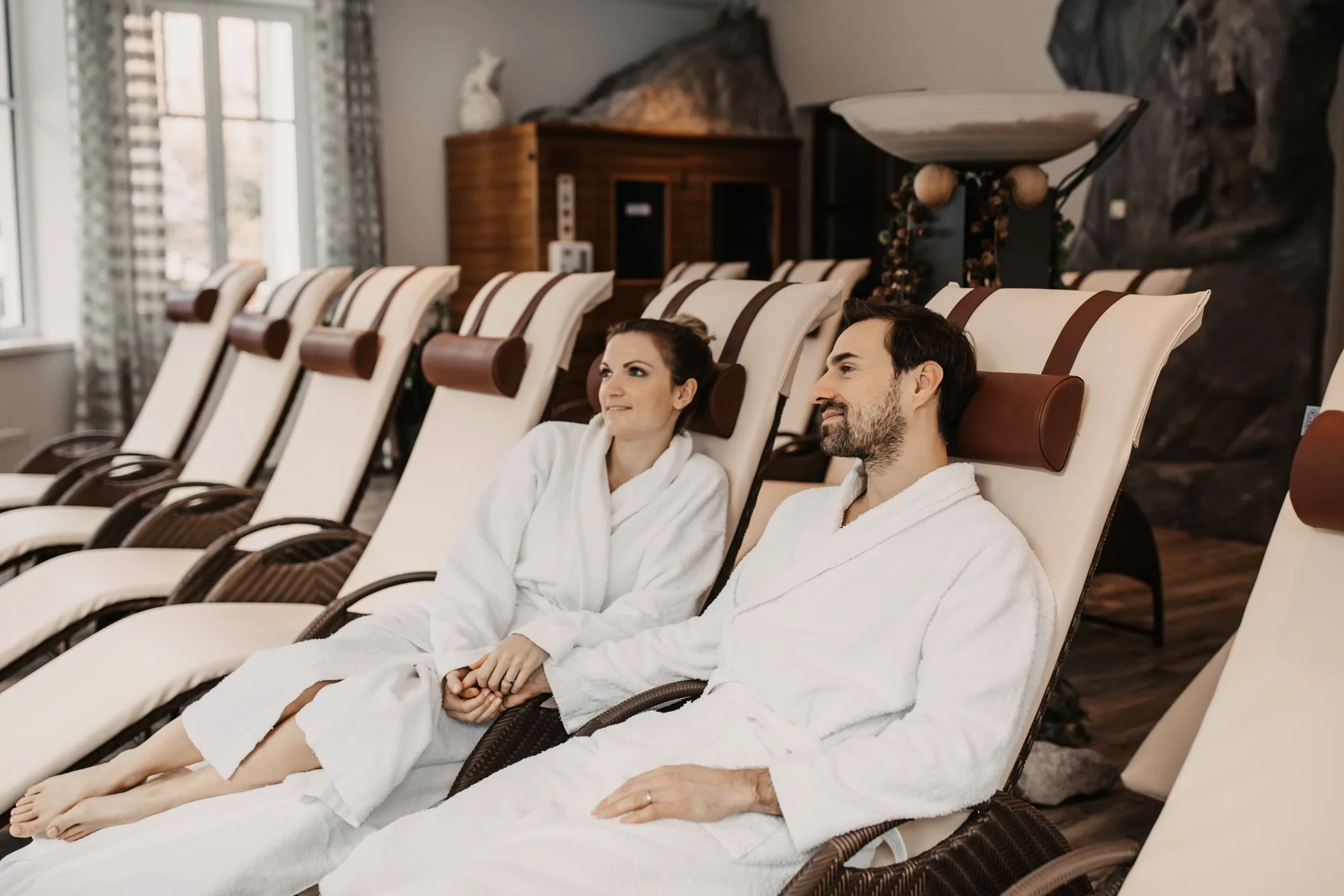 Pár v županech na lehátkách v relaxační zóně