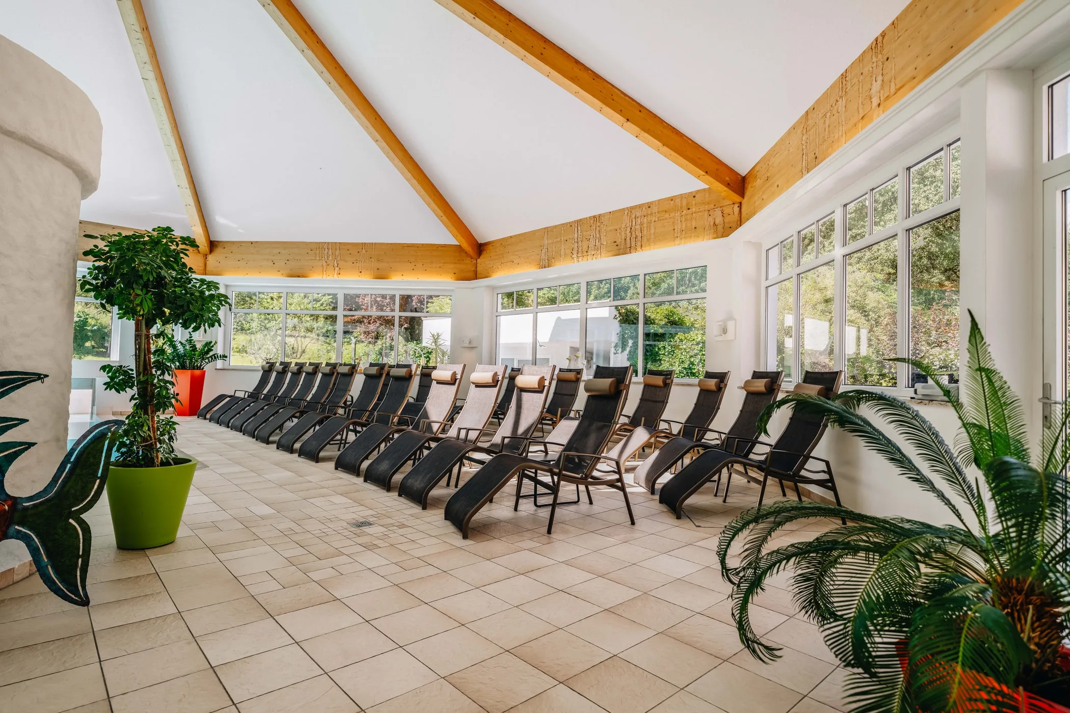 Dlouhá řada lehátek v relaxační zóně u okna