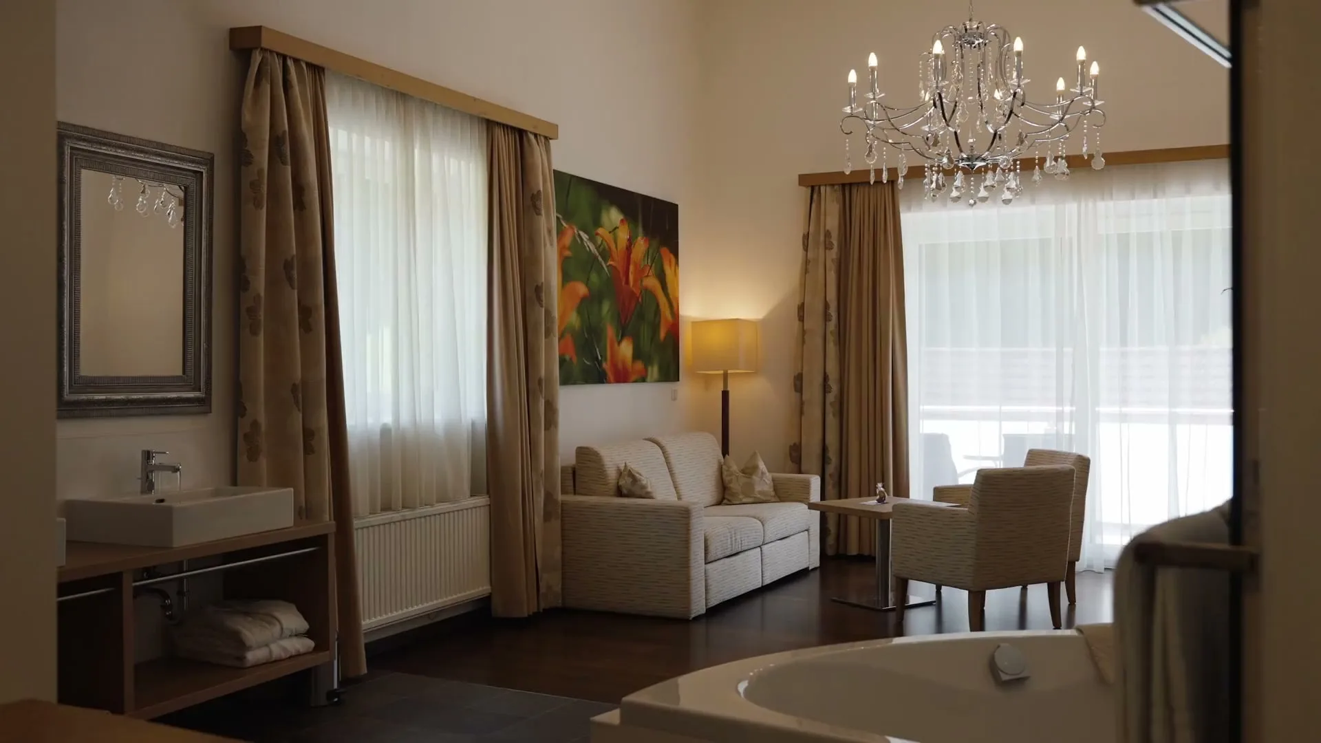 Die Wohlfühlsuite mit Doppelbett, Sitzplatz und Kronleuchter