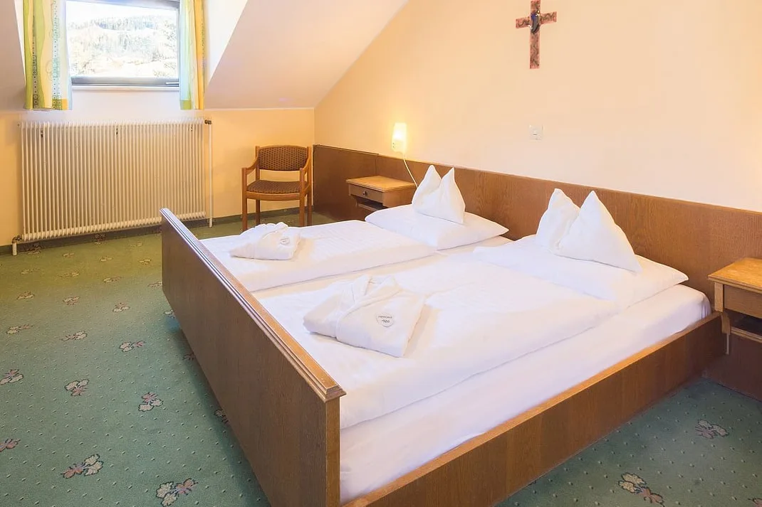 Doppelzimmer in der Mansarde mit Holzbett, Schreibtisch und Fernseher