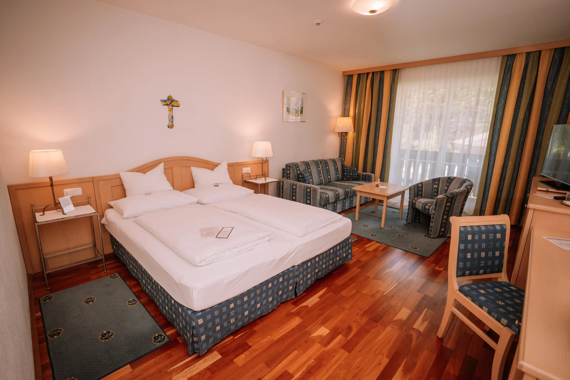 Pokoj Landhauszimmer s manželskou postelí, sedacím koutem a balkonovými dveřmi