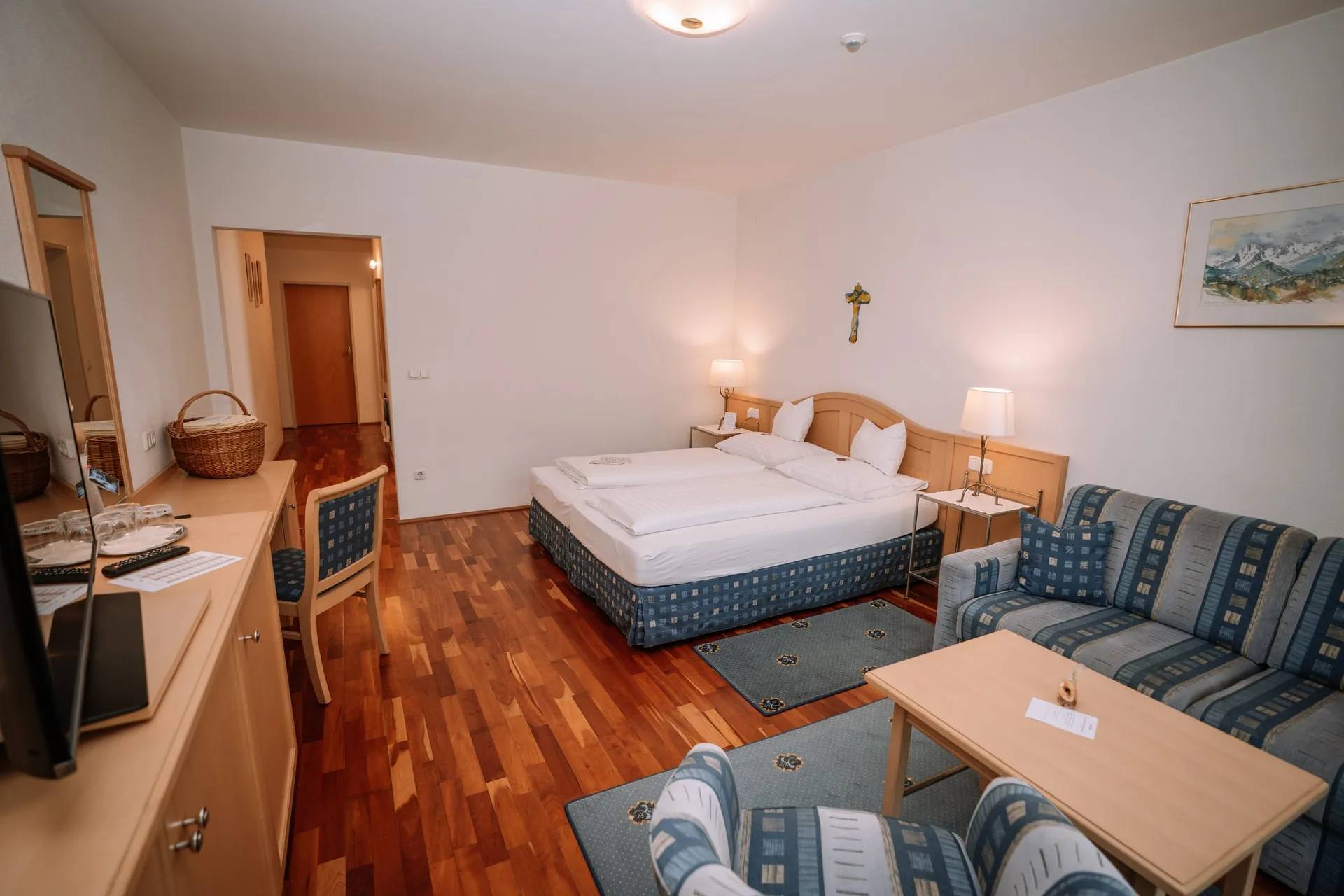 Landhauszimmer mit Sitzecke, Schreibtisch und Doppelbett