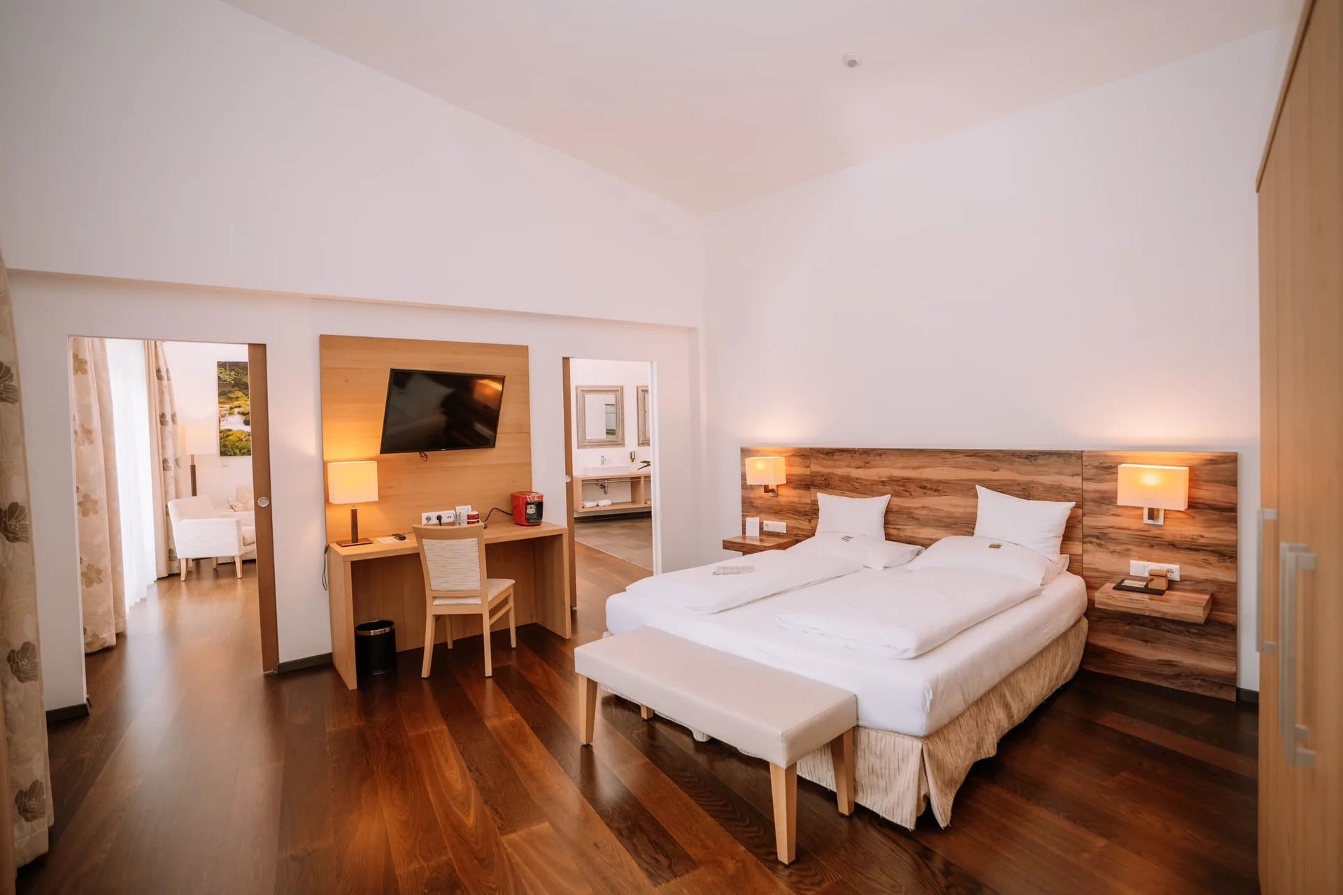 Wohlfühlsuite de luxe mit Doppelbett, Holzwand und Schreibtisch
