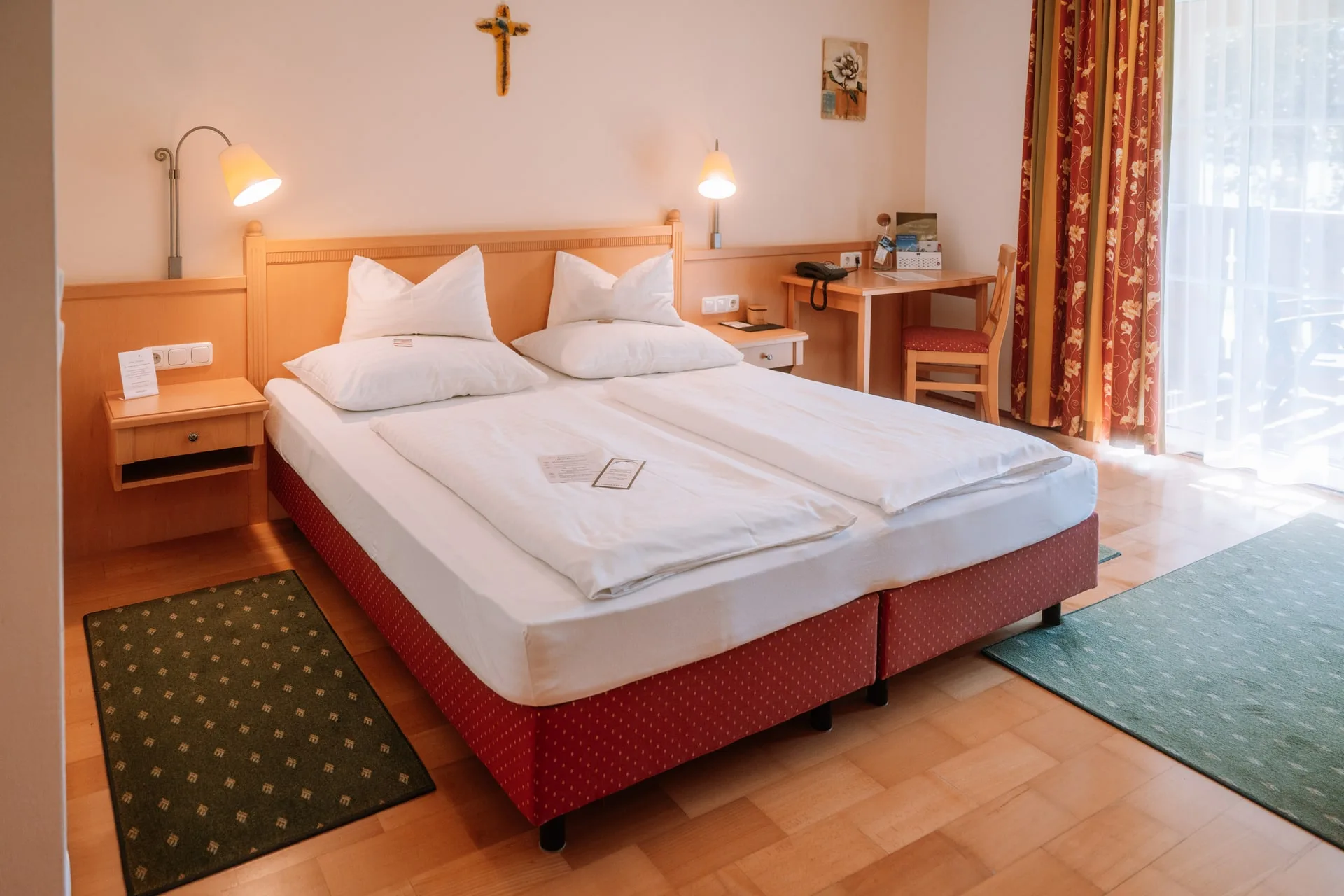 Pokoj Wohlfühlzimmer s manželskou postelí, psacím stolem a balkonovými dveřmi