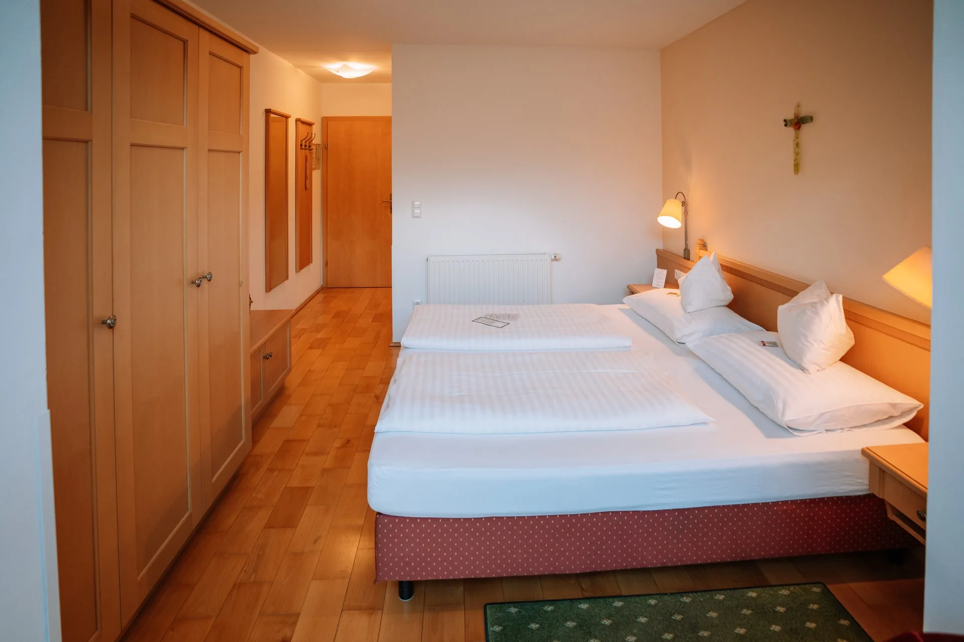 Doppelbett und Einbauschrank, im Hintergrund der Vorraum