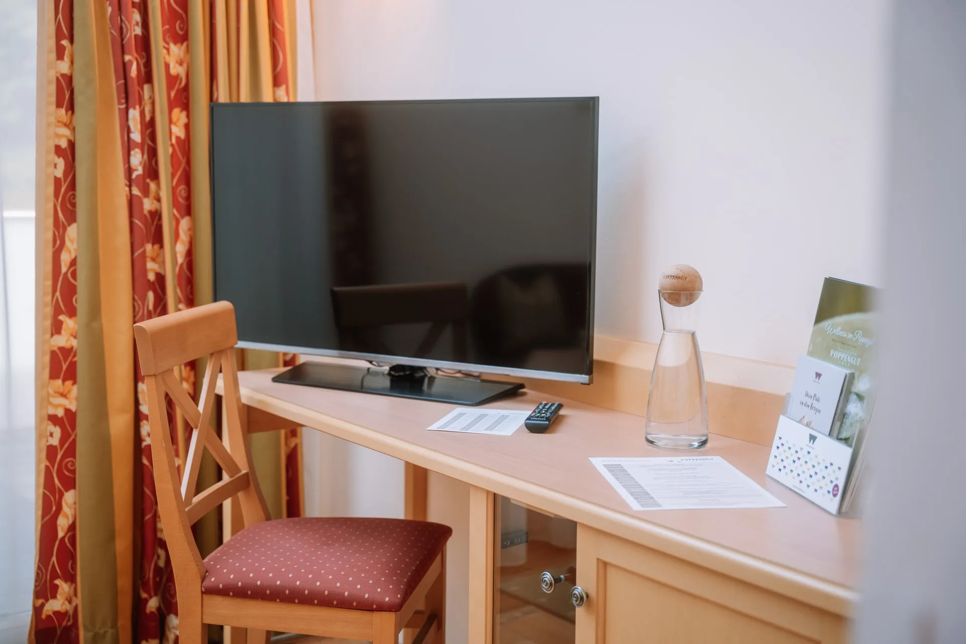 Schreibtisch mit Fernseher und Stuhl