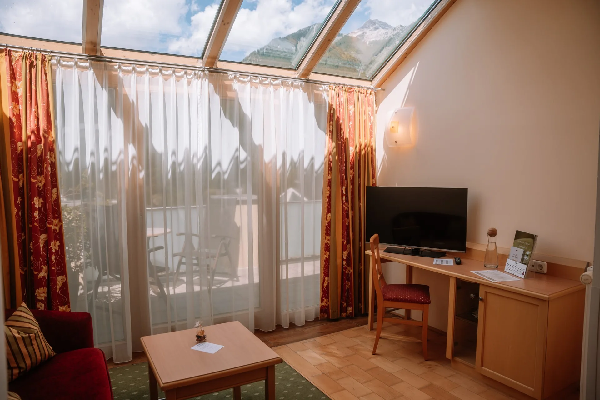 Wintergarten mit Glasdach, Schreibtisch und Fernseher